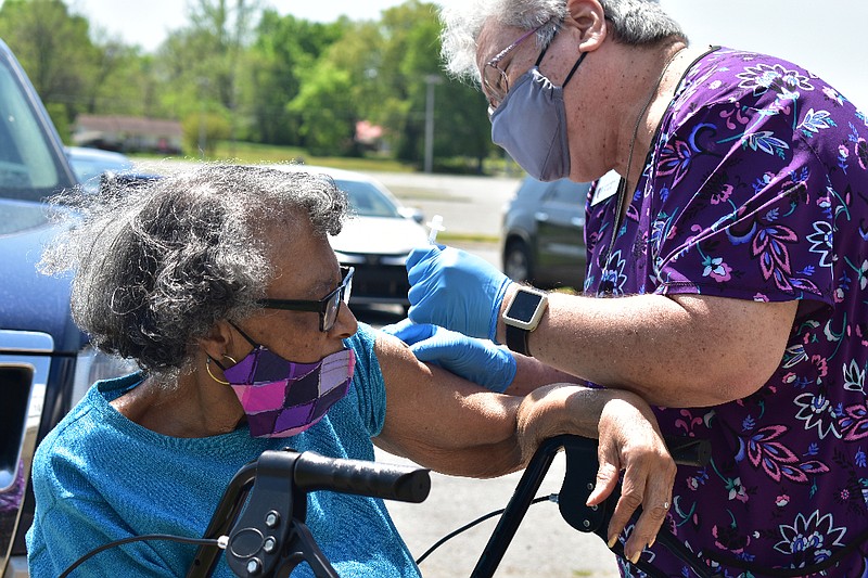 Ernestine Braswell, 84, of Pine Bluff receives her covid-19 vaccine from Area Agency on Aging nurse Kashimi Elkins on Tuesday, just outside the Sgt. Michael J. Strachota Senior Center. (Pine Bluff Commercial/I.C. Murrell)