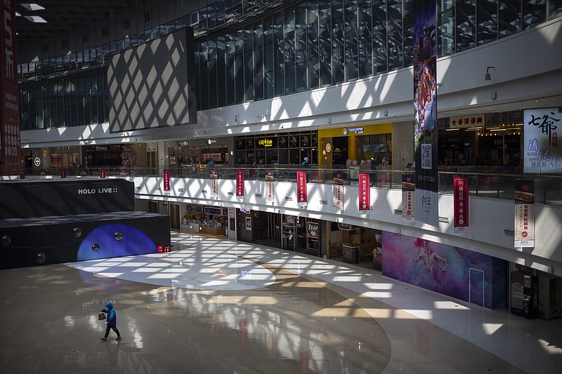 FILE - In this March 7, 2020, file photo, a deliveryman carries a food order as he walks through a mostly empty shopping mall in Beijing. China’s exports rose 30.6% over a year ago in March as global consumer demand strengthened and traders watched for signs of what President Joe Biden might do about reviving tariff war talks with Beijing. (AP Photo/Mark Schiefelbein, File)