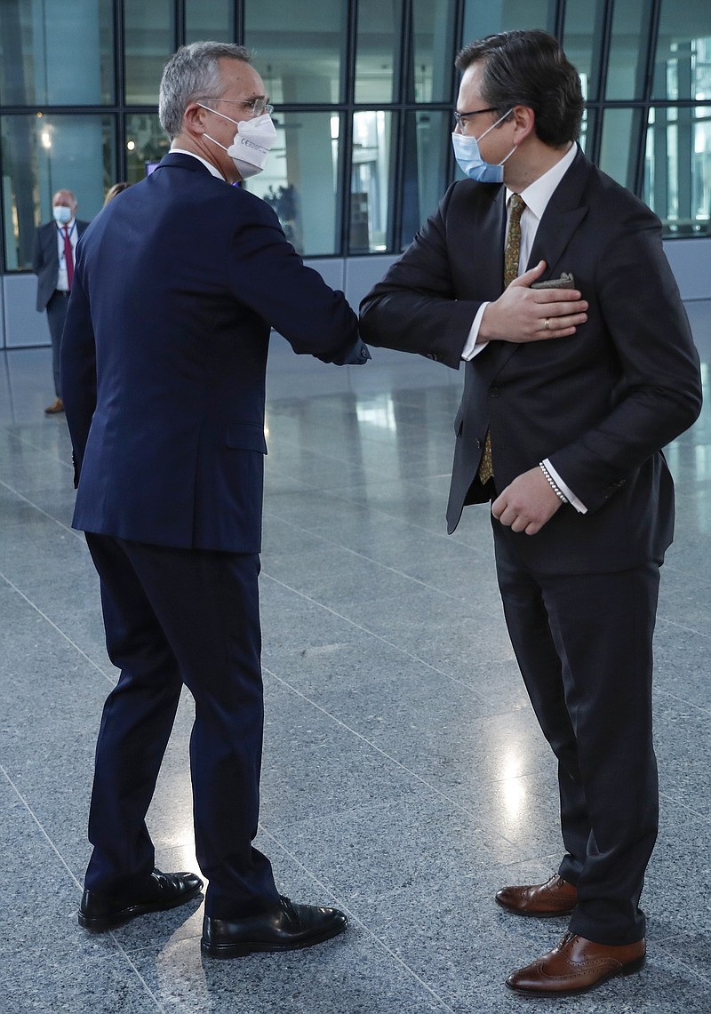 NATO Secretary General Jens Stoltenberg, left, greets Ukraine's Foreign Minister Dmytro Kuleba with an elbow bump prior to a meeting at NATO headquarters in Brussels, Tuesday, April 13, 2021. (AP Photo/Francisco Seco, Pool)