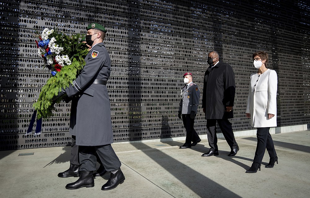Annegret Kramp-Karrenbauer, Federal Minister of Defence, and U.S. Secretary of Defence Lloyd Austin lay down a wreath at the Federal Ministry of Defence in Berlin, Germany, Tuesday, April 13, 2021. This is the first visit to Germany by a minister of the new US administration. Austin will then travel on to Stuttgart, where he will talk to soldiers at the US command centres for troops in Africa and Europe. (Kay Nietfeld/dpa via AP)