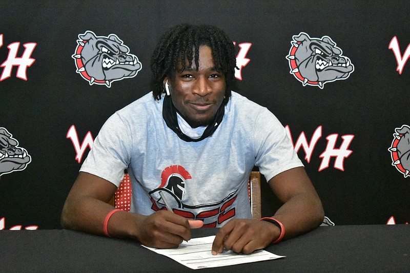 Jacobrien Eichelberger of White Hall signs his letter of intent with Mississippi Delta Community College on Wednesday at the White Hall High School library. (Pine Bluff Commercial/I.C. Murrell)