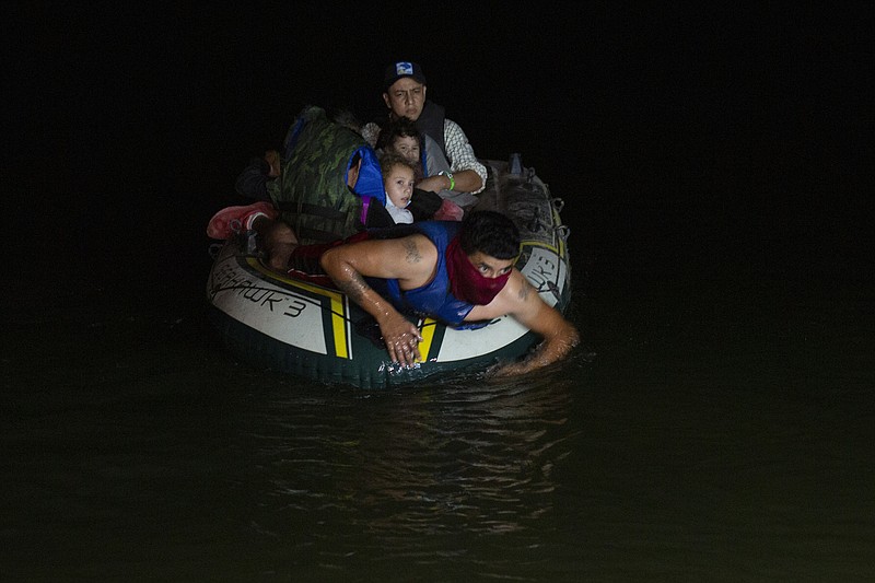 FILE - In this March 30, 2021 file photo, a smuggler takes migrants, mostly from Central American countries, on a small inflatable raft towards U.S. soil, in Roma, Texas. Mexico President Andres Manuel Lopez Obrador said Wednesday, April 14, 2021, it was protecting human rights that was motivating Mexico’s efforts to stop child migrants en route to the U.S. from being smuggled into the country. (AP Photo/Dario Lopez-Mills, File)