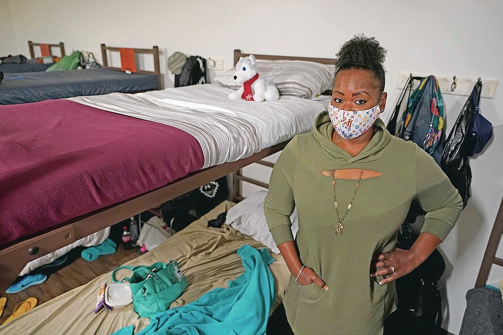 Cidney Oliver poses for a photo, Wednesday, April 7, 2021, by the bunk she sleeps on at a YWCA shelter for women lacking housing in Seattle. Earlier in the day, Oliver received the first dose of the Moderna COVID-19 vaccine at a clinic staffed by workers from Harborview Medical Center at the shelter. βIt was important for me to protect myself and the health and welfare of others,β Oliver said. (AP Photo/Ted S. Warren)
