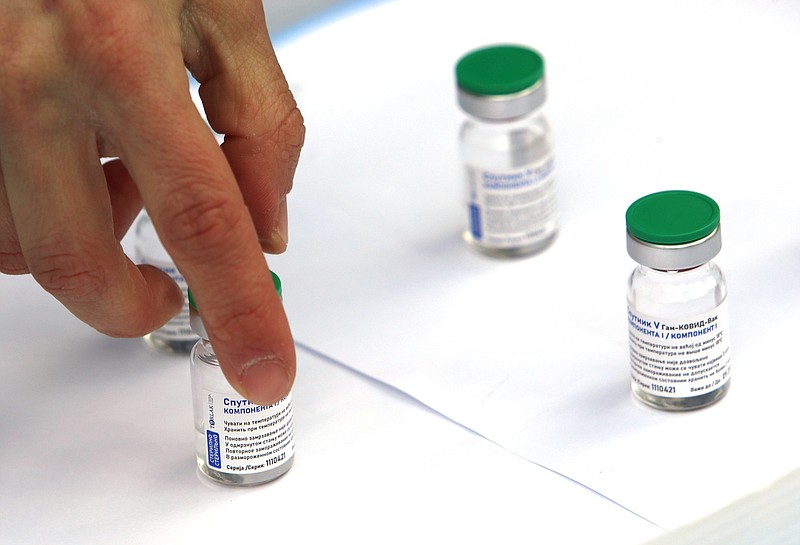 A Torlak Institute's employee arranges vials of the Sputnik V vaccine prior to the visit of Serbian President Aleksandar Vucic in Belgrade, Serbia, Thursday, April 15, 2021. Serbia has announced it will begin packing and later producing Russia's Sputnik V coronavirus vaccine, which would make it the first European state outside Russia and Belarus to begin manufacturing the jab. (AP Photo/Darko Vojinovic)