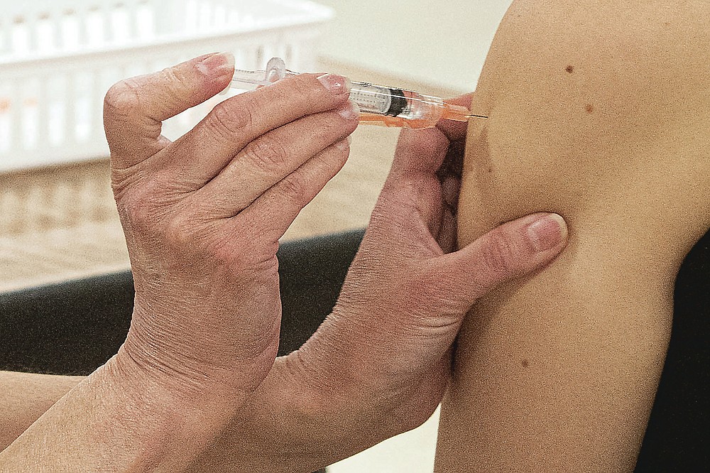 FILE- This April 8, 2021 file photo shows a COVID-19 vaccination being administered in Kent, Ohio. On Friday, April. 16, The Associated Press reported on stories circulating online incorrectly claiming COVID-19 vaccines are called Luciferase, have the patent number 060606 and come from a digital program called Inferno. (AP Photo/Phil Long, File)