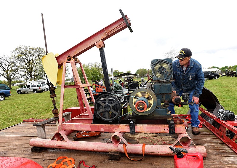 Keith Ellis of Inola, Okla., starts his 1950's era Fairbanks Morse oil field engine on Friday at the spring Tired Iron of the Ozarks antique tractor and engine show near Gentry. The show is free and continues today featuring an array of antique tractors, farm machinery, tools, a blacksmith shop and more at 13344 Taylor Orchard Road southwest of Gentry. The Tired Iron group hosts a show each April and September. 
(NWA Democrat-Gazette/Flip Putthoff)
