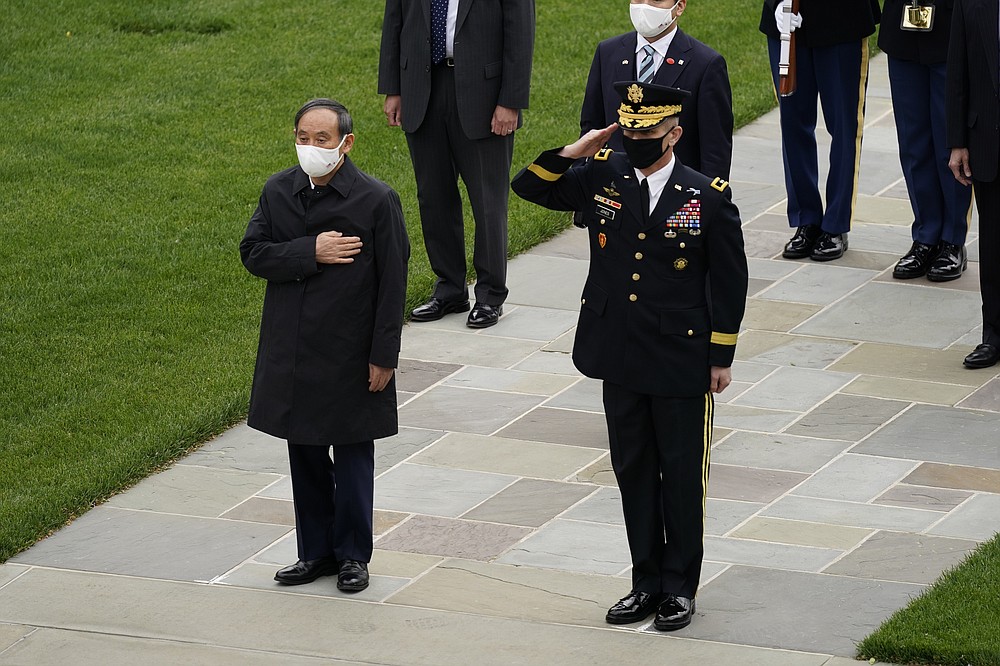 Japanese Prime Minister Yoshihide Suga at the Tomb of the Unknown Soldier for a wreath laying ceremony at Arlington National Cemetery in Arlington, Va., Friday morning, April 16, 2021, with U.S. Army Maj. Gen. Omar Jones. President Joe Biden will be welcoming Japan's prime minister to the White House on Friday in his first face-to-face meeting with a foreign leader, a choice that reflects Biden's emphasis on strengthening alliances to deal with a more assertive China and other global challenges. (AP Photo/Carolyn Kaster)