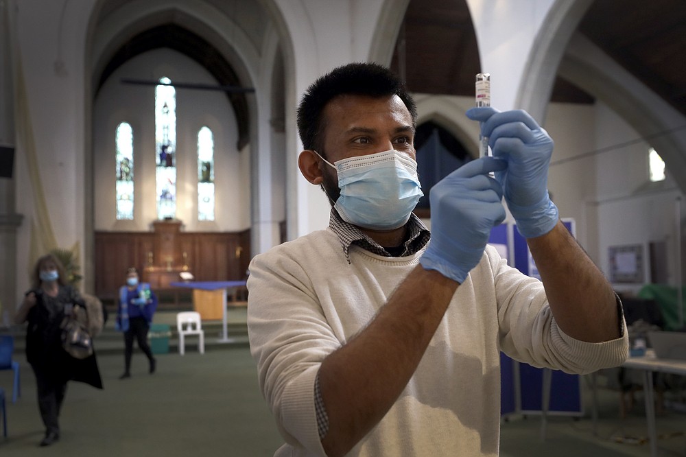 FILE - In this March 16, 2021, file photo, Pharmacist Rajan Shah prepares a syringe of the AstraZeneca vaccine at St John's Church, in Ealing, London. The global death toll from the coronavirus topped a staggering 3 million people Saturday, April 17, 2021, amid repeated setbacks in the worldwide vaccination campaign and a deepening crisis in places such as Brazil, India and France.  (AP Photo/Kirsty Wigglesworth, File)