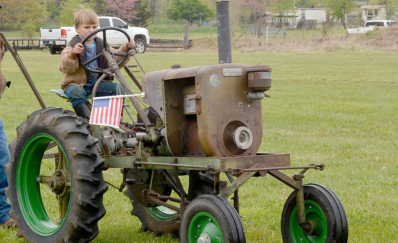 Marc Hayot/Herald-Leader During the parade at Tired Iron's spring show Anthony DeCamp drove a 1958 Shaw Tractor with his grandfather keeping a watchful eye on the young driver.