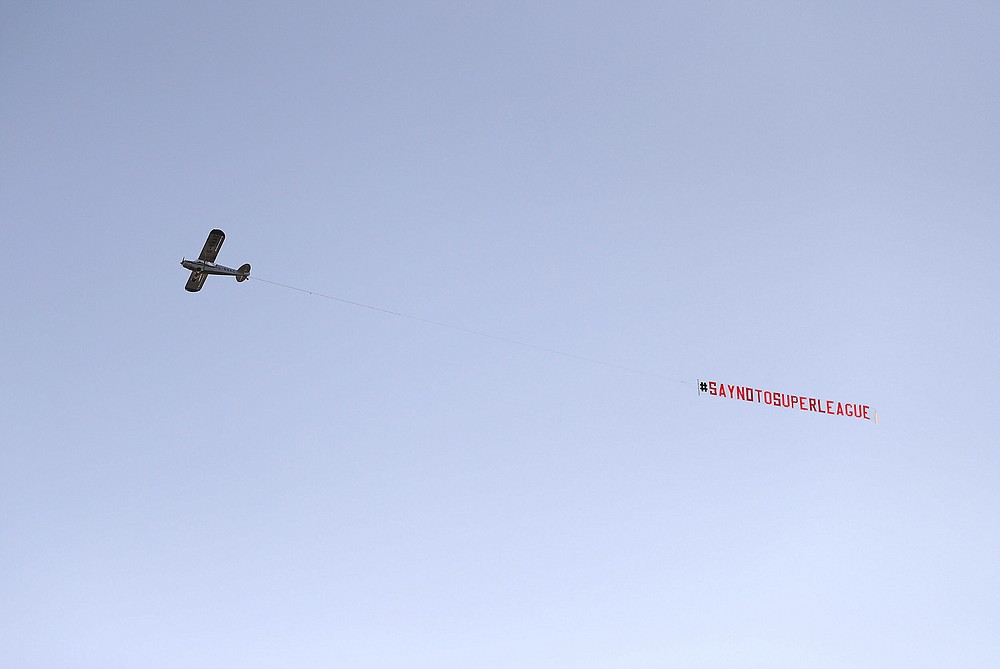 A plane with a 'Say No To Super League' banner flies over Elland Road, as a protest against Liverpool's decision to be included amongst the clubs attempting to form a new European Super League, in Leeds, England, Monday, April 19, 2021. Reaction to the proposals from 12 clubs to rip up European soccer by forming a breakaway Super League has ranged from anger and condemnation to humor and sarcasm. (Zac Goodwin/PA via AP)
