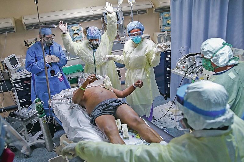Nurses and doctors clear themselves before defibrillating a patient who tested positive for COVID-19 and suddenly went "Code 99," or into cardiac arrest, in Yonkers, N.Y., April 20, 2020. The emergency room team successfully revived the patient. Associated Press photographer John Minchillo says of witnessing their heroic efforts: “Seeing the medical team risk death to save the life of a stranger, knowing the air surrounding us was teeming with particles from intubated patients' lungs, left me grateful for good people in this world. My respect for these New Yorkers is boundless.” (AP Photo/John Minchillo)