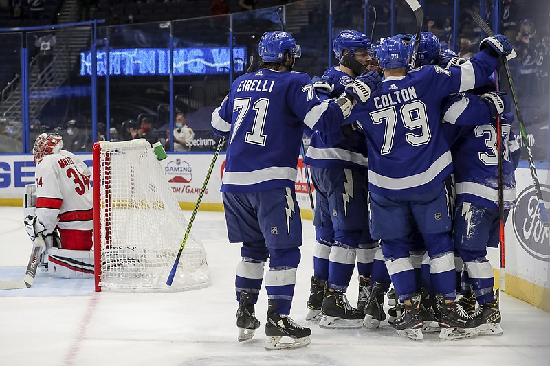 Members of the Tampa Bay Lightning celebrate their winning goal as Carolina Hurricanes goaltender Petr Mrazek, of the Czech Republic, reacts during the overtime period of Monday's game in Tampa, Fla. - Photo by Mike Carlson of The Associated Press