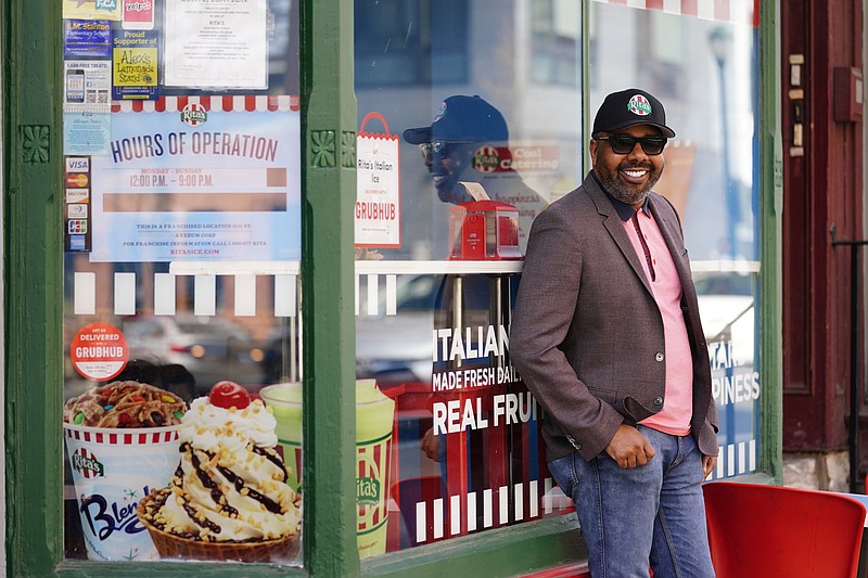 Business owner Aaron Anderson who operators multiple restaurants poses for a photograph at his Rita's Italian Ice location in Philadelphia, Friday, March 26, 2021.  Restaurants and delivery companies remain uneasy partners, haggling over fees and struggling to make the service profitable for themselves and each other.  Anderson thinks delivery fees are too high. But he also sees some value in delivery companies, which can help restaurants test new concepts. (AP Photo/Matt Rourke)