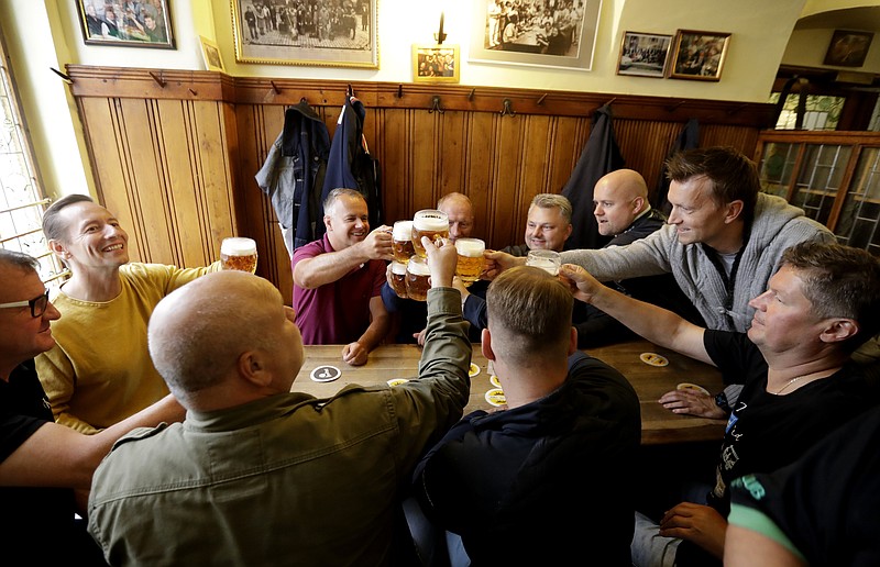 FILE - In this Monday, May 25, 2020 file photo, customers cheer with beer as a traditional beer pub opens in Prague, Czech Republic. The coronavirus pandemic has affected the beer consumption in the Czech Republic last year. In the beer loving nation that tops the world of drinkers per capita, an average consumption per one person dropped by seven liters. (AP Photo/Petr David Josek, file)