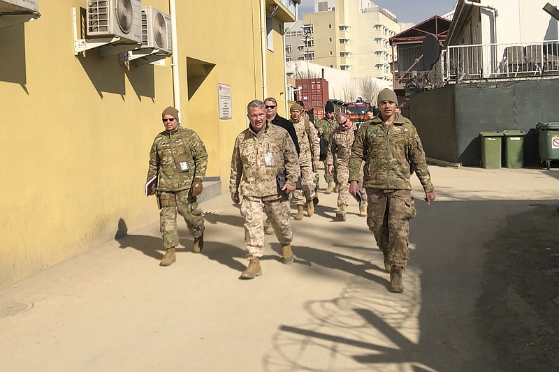 FILE - In this Jan. 31, 2020, file photo Marine Gen. Frank McKenzie, center, top U.S. commander for the Middle East, makes an unannounced visit in Kabul, Afghanistan. Without coming right out and saying it, President Joe Biden seems ready to let lapse a May 1 deadline for completing a withdrawal of U.S. troops from Afghanistan. Orderly withdrawals take time, and Biden is running out of it. (AP Photos/Lolita Baldor, File)