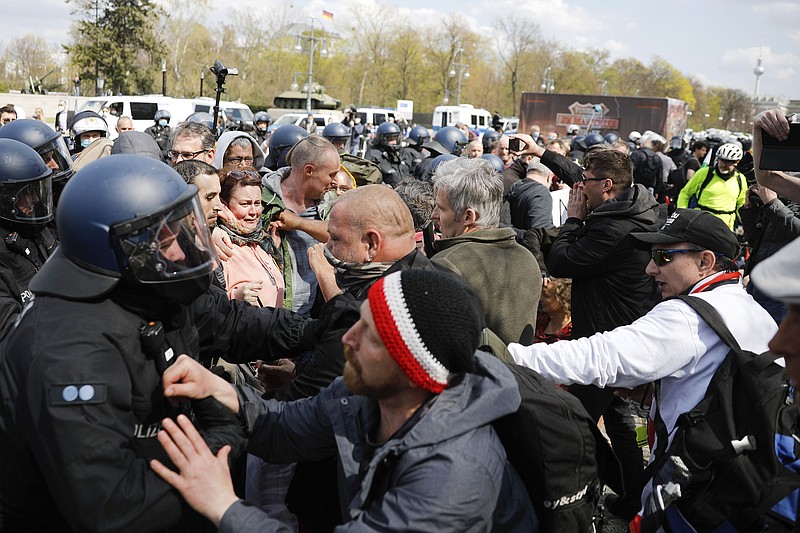 Demonstrators face off with police Wednesday in Berlin as officers break up a rally against the German government’s coronavirus policies. Lawmakers on Wednesday approved uniform “emergency brake” restrictions for when the virus is spreading too quickly, replacing a patchwork of measures across Germany’s 16 states.
(AP/Markus Schreiber)