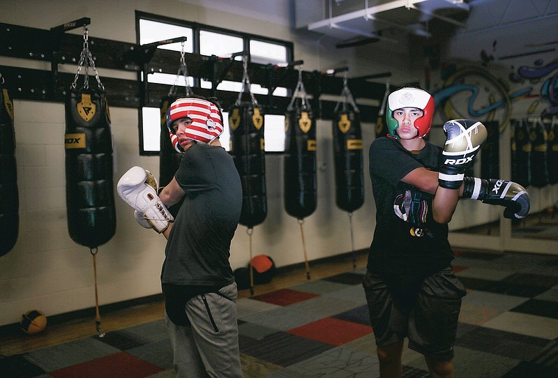 Joshua Jones, 17, (from left) and Ricardo "Gordo" Palos, 15, stretch before sparring, Saturday, April 17, 2021 at Straightright Boxing & Fitness in Springdale. Check out nwaonline.com/210420Daily/ for today's photo gallery. 
(NWA Democrat-Gazette/Charlie Kaijo)
