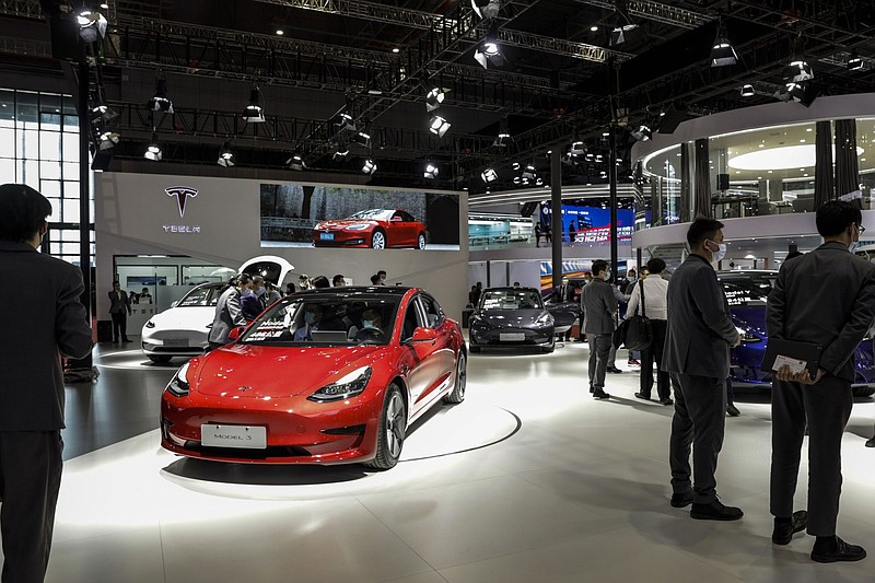Visitors walk past Chinese-made Tesla Inc. electric vehicles at the company's booth at the Auto Shanghai 2021 show. MUST CREDIT: Bloomberg photo by Qilai Shen.