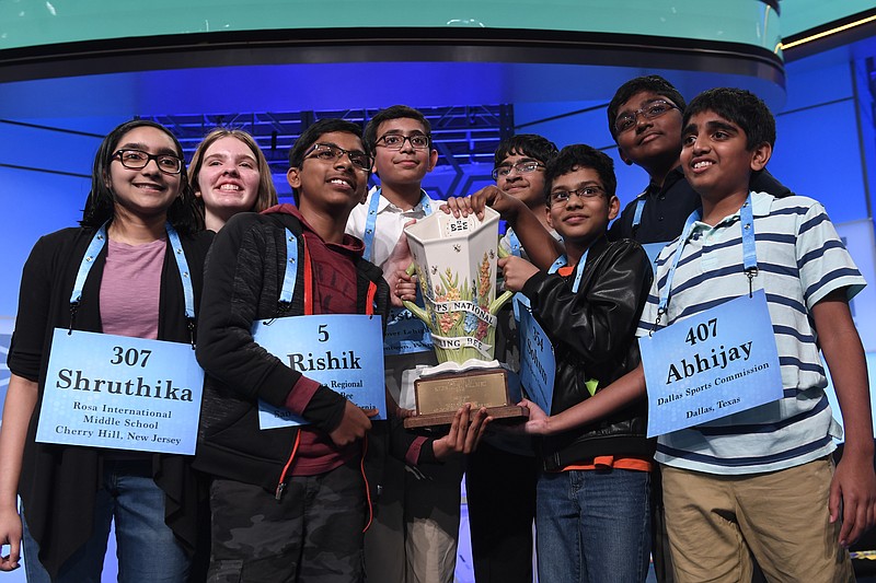 FILE - In this Friday, May 31, 2019 file photo, the eight co-champions of the 2019 Scripps National Spelling Bee, from left, Shruthika Padhy, 13, of Cherry Hill, N.J., Erin Howard, 14, of Huntsville, Ala., Rishik Gandhasri, 13, of San Jose, Calif., Christopher Serrao, 13, of Whitehouse Station, N.J., Saketh Sundar, 13, of Clarksville, Md., Sohum Sukhatankar, 13, of Dallas, Texas, Rohan Raja, 13, of Irving, Texas, and Abhijay Kodali, 12, of Flower Mound, Texas, hold the trophy at the end of the competition in Oxon Hill, Md. The Scripps National Spelling Bee is undergoing a major overhaul to ensure it can identify a single champion, adding vocabulary questions and a lightning-round tiebreaker to this year's pandemic-altered competition, Friday, April 23, 2021. (AP Photo/Susan Walsh, File)