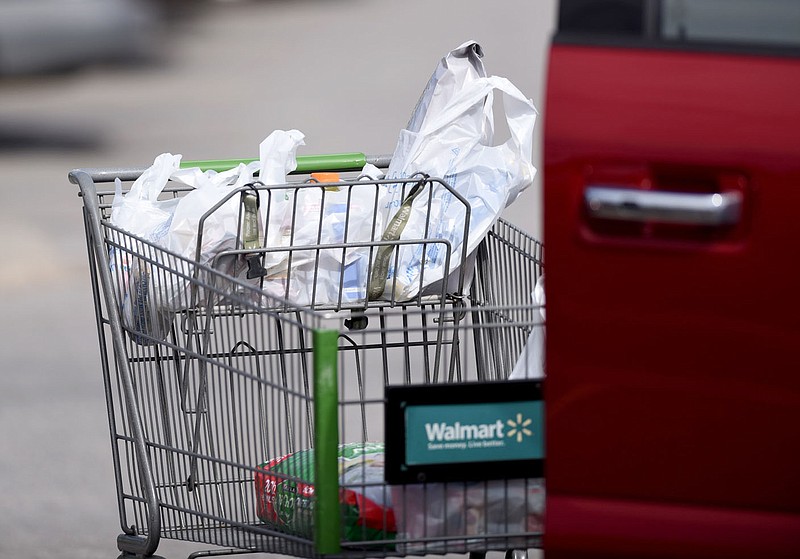 Recently purchased groceries are transported in plastic bags are visible Feb. 27, 2020, in the parking lot of the Walmart Neighborhood Market on Martin Luther King Drive in Fayetteville. The city adopted a ban on single-use polystyrene foam containers and was considering a 10-cent fee on plastic bags that has been rendered unenforceable by recent state law.
(File photo/NWA Democrat-Gazette/David Gottschalk)