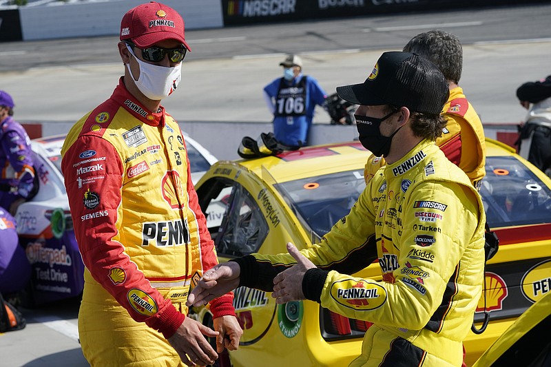 Joey Logano, left, and Ryan Blaney, right talk on pit row prior to the start of the NASCAR Cup Series auto race at Martinsville Speedway in Martinsville, Va., Sunday, April 11, 2021. (AP Photo/Steve Helber)