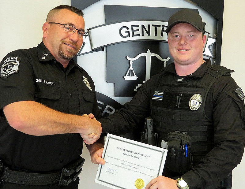Westside Eagle Observer/RANDY MOLL
Chief Clay Stewart presents a life-saver award to Gentry police officer Matthew Easter on April 20 to recognize his actions in saving the life of a Gentry resident who suffered a life-threatening gunshot wound from an accidental discharge.