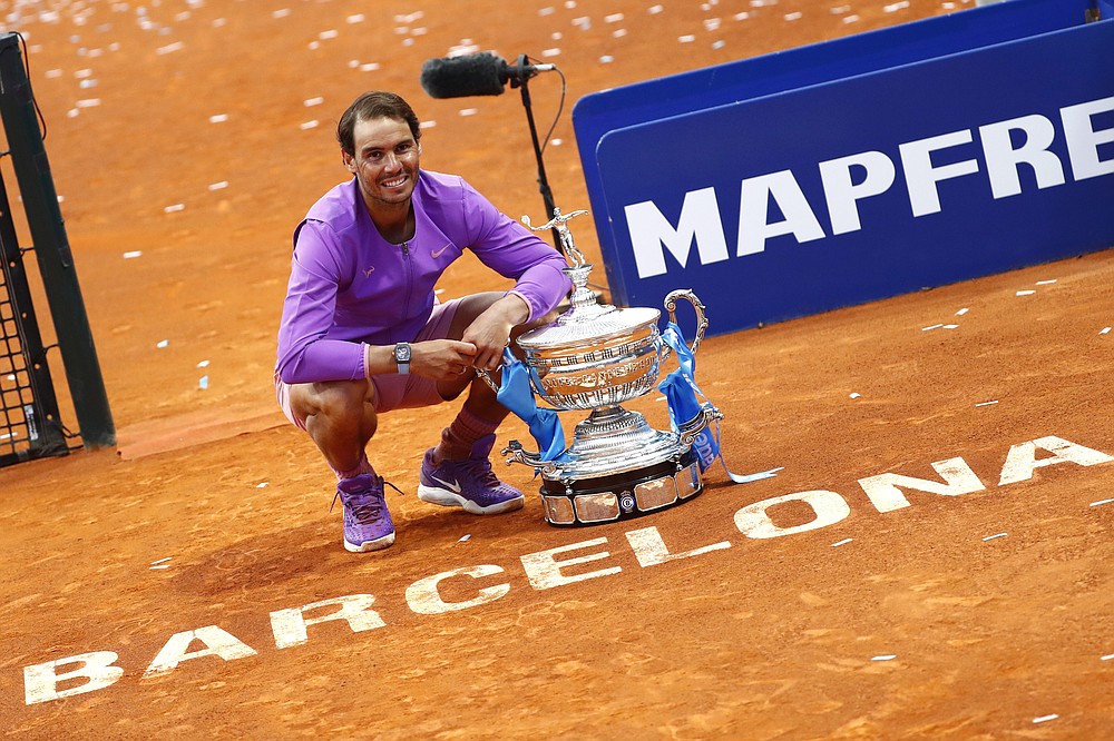 Rafael Nadal of Spain poses for a photo next to the trophy after winning the final Godo tennis tournament against Stefanos Tsitsipas of Greece in Barcelona, Spain, Sunday, April 25, 2021. Nadal won by 6-4, 6-7, 7-5 (AP Photo/Joan Monfort)