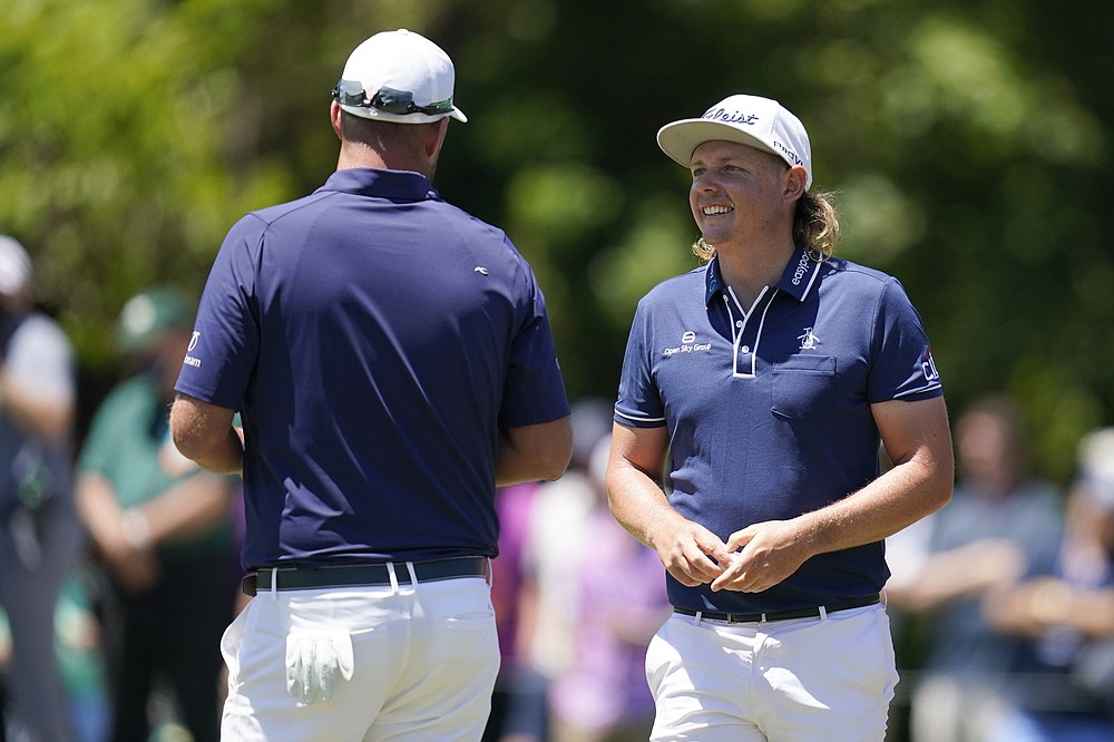Cameron Smith, of Australia, talks with his teammate Marc Leishman, of Australia, left, after making his putt on the first green during the final round of the PGA Zurich Classic golf tournament at TPC Louisiana in Avondale, La., Sunday, April 25, 2021. (AP Photo/Gerald Herbert)