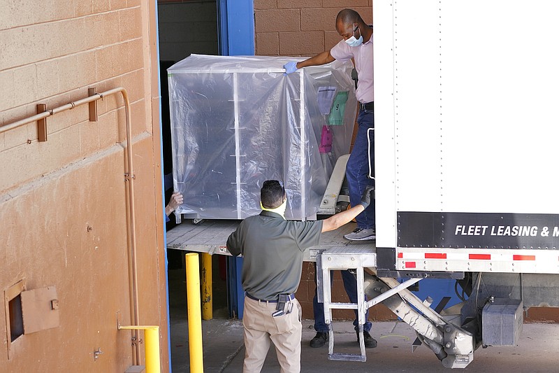 FILE - In this Wednesday, April 21, 2021 file photo, officials unload election equipment into the Veterans Memorial Coliseum at the state fairgrounds in Phoenix. Maricopa County officials began delivering equipment used in the November election won by President Joe Biden on Wednesday and will move 2.1 million ballots to the site Thursday so Republicans in the state Senate who have expressed uncertainty that Biden's victory was legitimate can recount them and audit the results. (AP Photo/Matt York)
