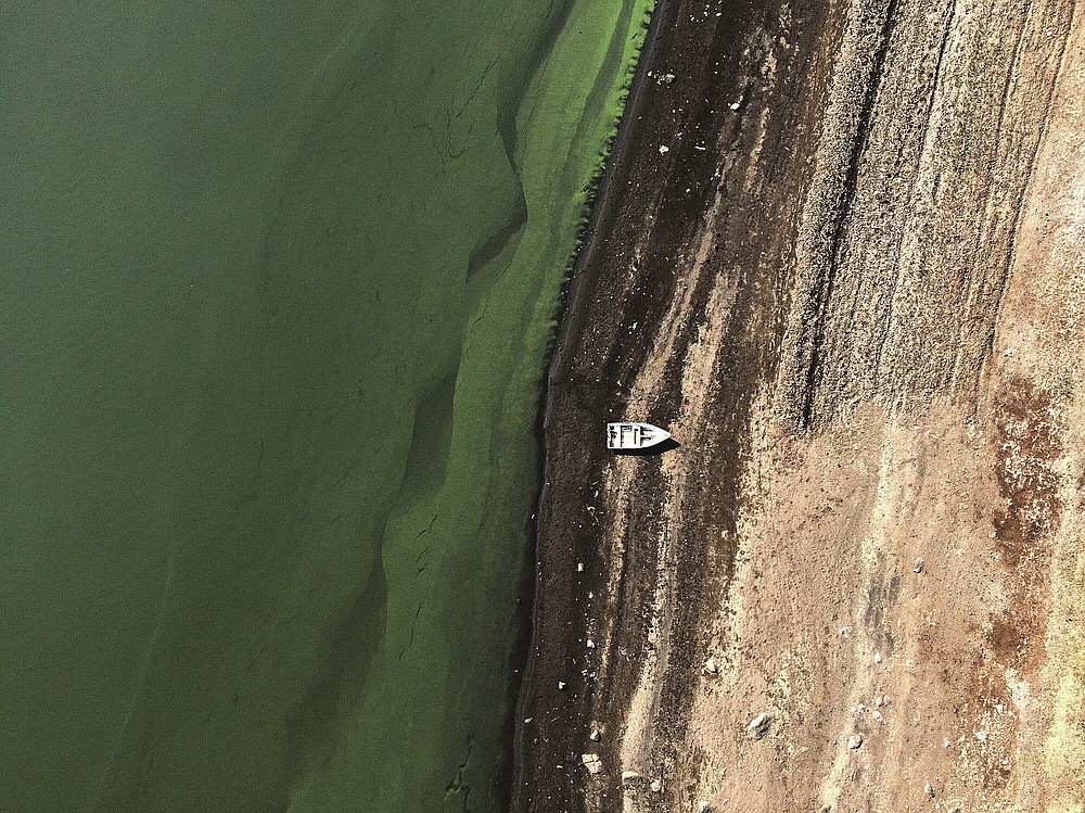 A boat sits idle on the banks of Villa Victoria Dam, the main water supply for Mexico City residents, on the outskirts of Toluca, Mexico, Thursday, April 22, 2021. The mayor of Mexico City said the drought was the worst in 30 years, and that problem can be seen at the series of reservoirs that bring in water from other states to supply the capital. (AP Photo/Fernando Llano)