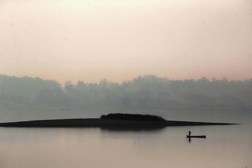 A man stands up on his boat as he fishes in the waters of the Villa Victoria Dam, the main water supply for Mexico City residents, on the outskirts of Toluca, Mexico Thursday, April 22, 2021. Drought conditions now cover 85% of Mexico, and in areas around Mexico City and Michoacán, the problem has gotten so bad that lakes and reservoirs are drying up. (AP Photo/Fernando Llano)