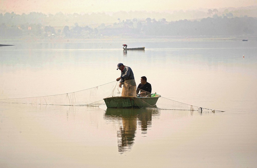 Fishermen fish in the waters of the Villa Victoria Dam, the main water supply for Mexico City residents, on the outskirts of Toluca, Mexico Thursday, April 22, 2021. Drought conditions now cover 85% of Mexico, and in areas around Mexico City and Michoacán, the problem has gotten so bad that lakes and reservoirs are drying up. (AP Photo/Fernando Llano)