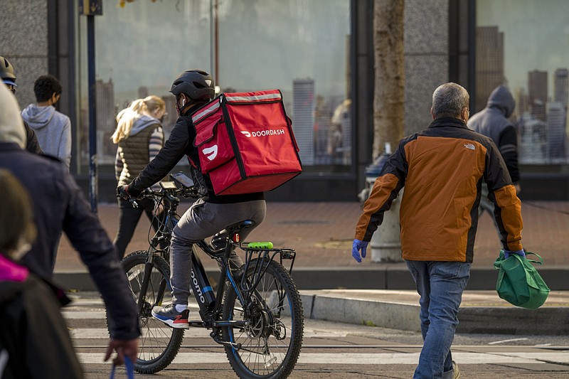 A bike messenger carries a DoorDash bag in San Francisco on Dec. 23, 2020. MUST CREDIT: Bloomberg photo by David Paul Morris