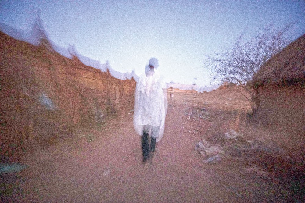 Tigrayan refugee Abraha Kinfe Gebremariam, 40, walks back to his shelter after praying at a church early in the morning in Hamdayet, eastern Sudan, near the border with Ethiopia, on March 21, 2021. As his family crossed the Tekeze River, leaving the Tigray bloodshed behind, he felt the burden of the previous month ease. “I was 100% sure the babies would grow up, that things would change from that moment,” he said. “Somehow my stress melted away. There were no more fears for our lives.” (AP Photo/Nariman El-Mofty)