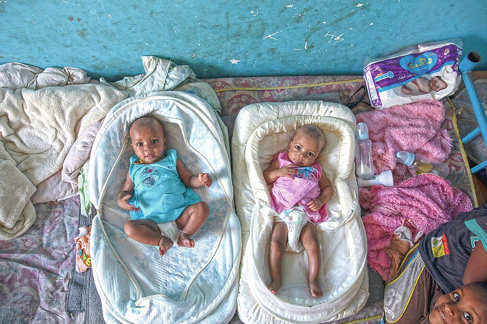 Tigrayan 4-month-old twin sisters Aden, left, and Turfu Gebremariam, lie together inside their family's shelter in Hamdayet, eastern Sudan, near the border with Ethiopia, on March 21, 2021. In the fear and despair of the days following their birth, the twins were left unnamed. There was simply no time. Finally, their young brother, Micheale, christened them himself. One of the girls was named Aden, or “paradise.” The other, who reminds people of her mother, was named Turfu, or “left behind.” (AP Photo/Nariman El-Mofty)