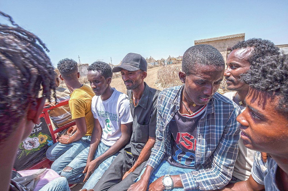 Tigrayan refugee Abraha Kinfe Gebremariam, 40, center, rides home after going to the market in Hamdayet, eastern Sudan, near the border with Ethiopia, on March 21, 2021. (AP Photo/Nariman El-Mofty)