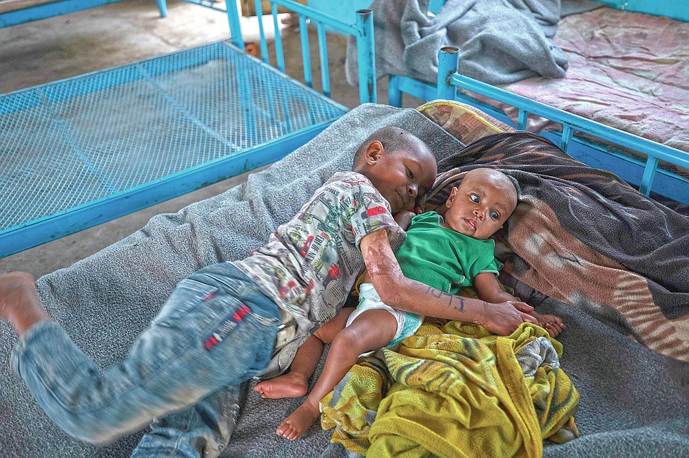 Tigrayan 5-year-old refugee Micheale Gebremariam hugs his 4-month-old sister, Aden, after waking up early in the morning in their shelter in Hamdayet, eastern Sudan, near the border with Ethiopia, on March 21, 2021. (AP Photo/Nariman El-Mofty)