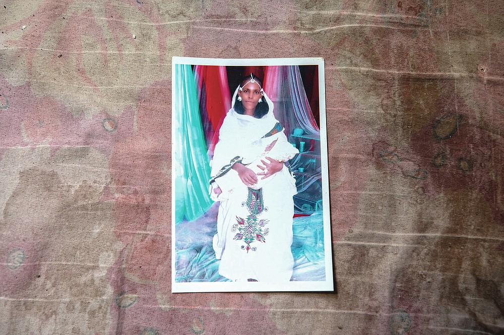 A photograph of Letay, the deceased wife of 40-year-old Tigrayan Abraha Kinfe Gebremariam, is seen inside her family's shelter in Hamdayet, eastern Sudan, near the border with Ethiopia, on March 14, 2021. Letay experienced a seemingly normal pregnancy in the Tigrayan region of Ethiopia. But ten days after giving birth to twin daughters, she passed away. (AP Photo/Nariman El-Mofty)