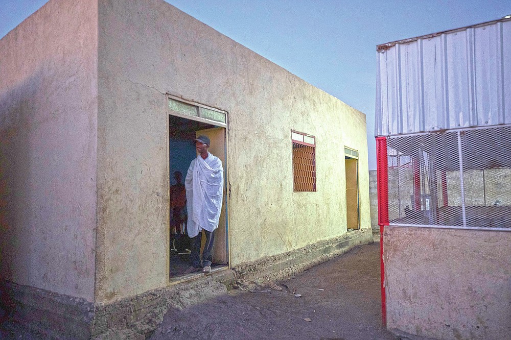 Tigrayan refugee Abraha Kinfe Gebremariam, 40, stands in a doorway of his family's shelter early morning in Hamdayet, eastern Sudan, near the border with Ethiopia, on March 21, 2021. His village of Mai Kadra was the first known massacre of a conflict in which thousands of ethnic Tigrayans like his family have been killed. (AP Photo/Nariman El-Mofty)