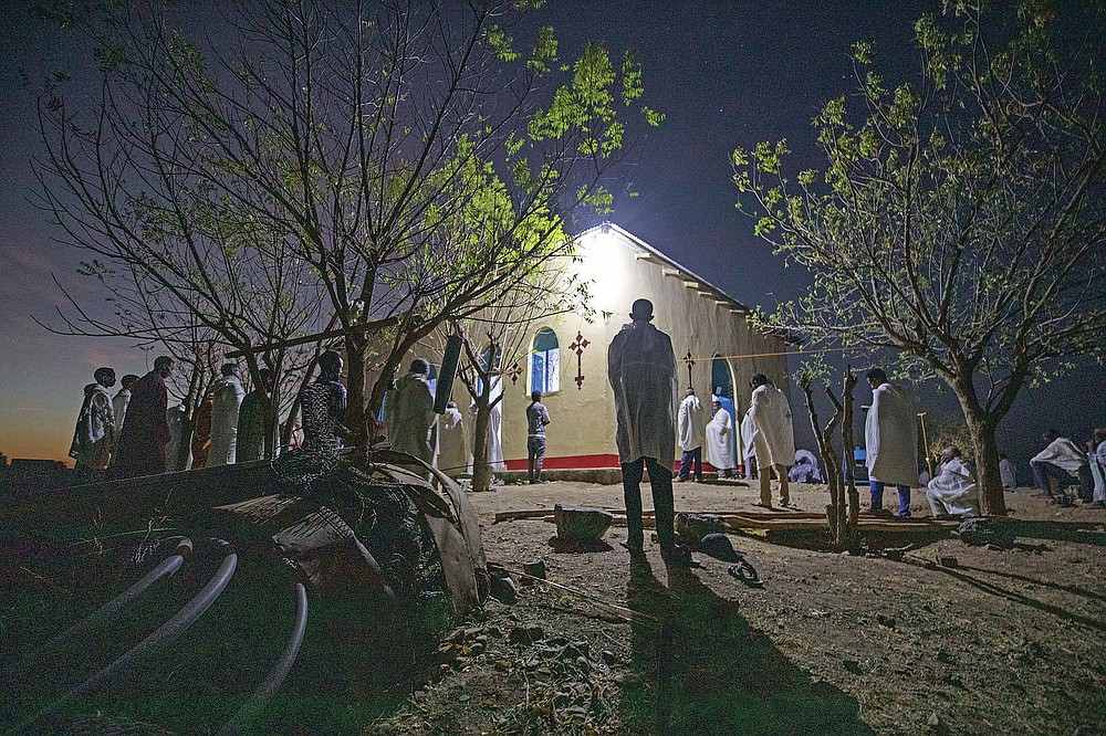 Tigrayan refugee Abraha Kinfe Gebremariam, 40, center, prays at a church early in the morning in Hamdayet, eastern Sudan, near the border with Ethiopia, on March 21, 2021. (AP Photo/Nariman El-Mofty)
