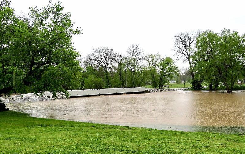 Westside Eagle Observer/RANDY MOLL
The new bridge over Flint Creek on Dawn Hill East Road in Gentry was being put to the test on Wednesday morning with the flooded creek reaching within inches of the bottom of the bridge. The bridge, which was completed in August 2020, is designed to be overflowed should the creek rise to that level. In 2017, spring flooding caused scouring and undermining to the support structures of the bridge when debris packed under the bridge and forced water to flow around it.