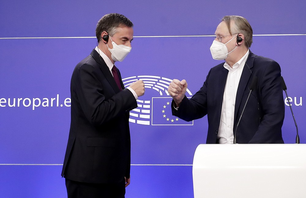 Member of European Parliament and Chair of the Committee on Foreign Affairs David McAllister, left, and Chair of the Committee on International Trade Bernd Lange greet each other during a media conference after a debate on the EU-UK trade and cooperation agreement at the European Parliament in Brussels, Tuesday, April 27, 2021. (Olivier Hoslet, Pool via AP)