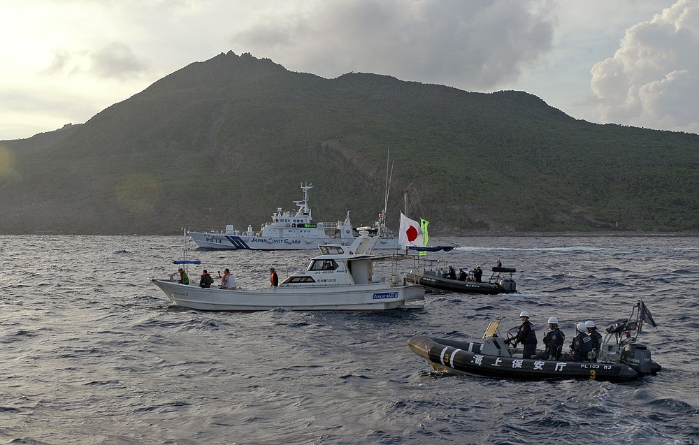 ファイル-2013年8月18日日曜日、ファイル写真、日本の沿岸警備隊の船と船この写真ではなく、日本の活動家の漁船と航海し、日本とDiaoyuがSenkakuという紛争の島のグループで活動家に警告を送信します。 中国、 日本は2021年4月28日、軍部が制御している尖閣島の周りの境界レベルを高めたが、中国の軍艦6隻がこのエリアの近くを通過して偵察ヘリコプターがその地域に向かって飛んで行った後、北京が主張しました。  （AP写真/ Emily Wang、ファイル）