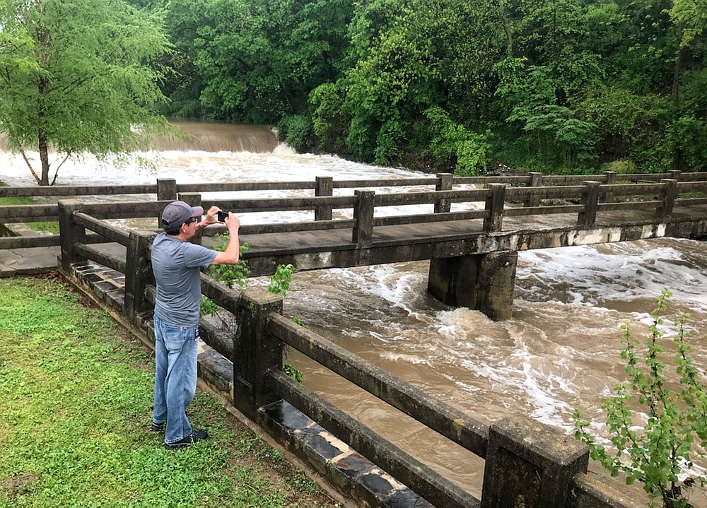 Janelle Jessen/Siloam Sunday
John Christie takes a picture of floodwaters in Sager Creek on Wednesday afternoon.