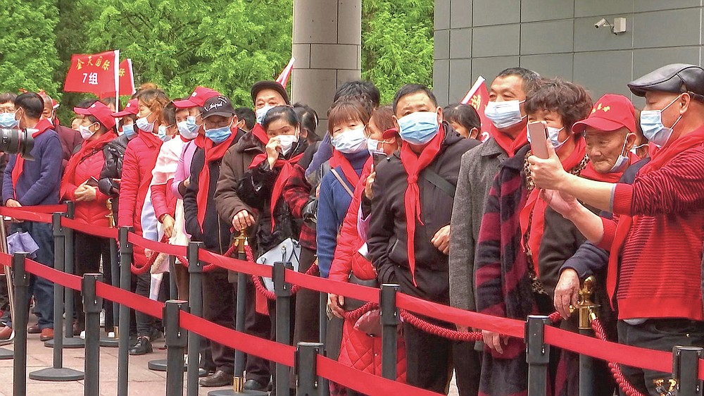 Tourist groups stand in line to enter the Jinggangshan Revolution Museum in Jinggangshan in southeastern China's Jiangxi province, on April 8, 2021. On the hundredth anniversary of the Chinese Communist Party, tourists in China are flocking to historic sites and making pilgrimages to party landmarks. (AP Photo/Emily Wang)