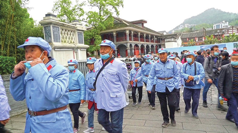 Tourists from the southern Henan province wear Red Army uniforms as they walk towards the Zunyi Memorial Museum in the city of Zunyi in Southwestern China's Guizhou province on April 12, 2021. The museum, located at the site of the Zunyi Conference, was where the late Communist leader Mao Zedong rose to power. (AP Photo/Emily Wang)