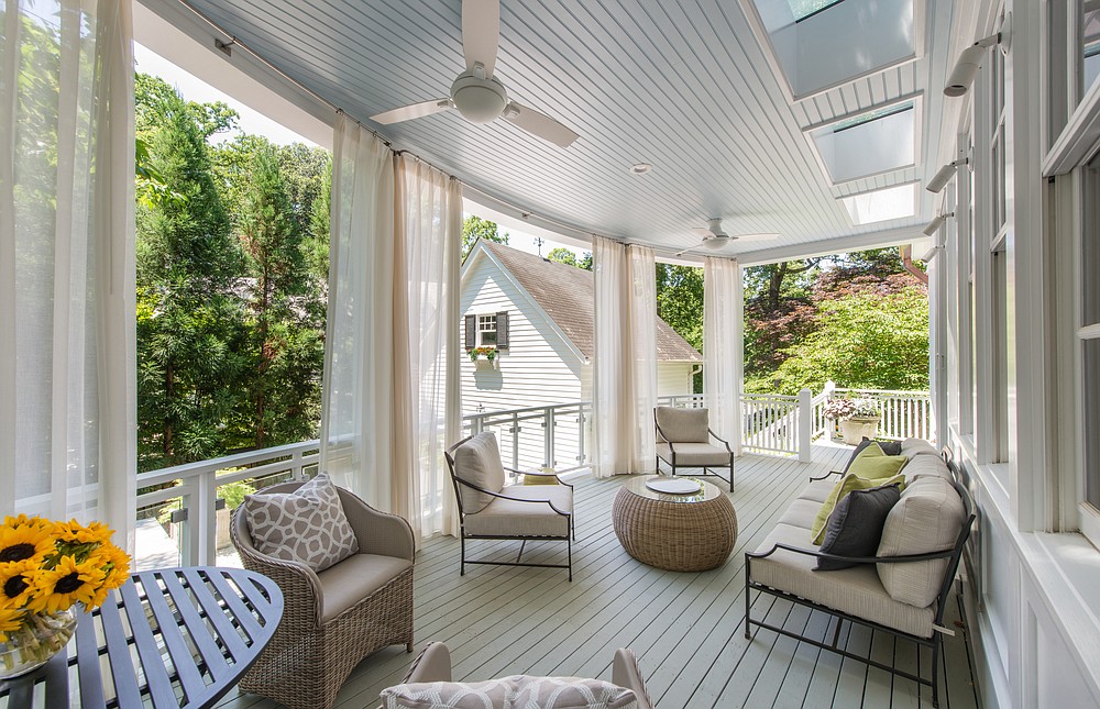 A terrace designed by Anthony Wilder Design/Build has furniture by Brown Jordan and drapes from Perennials to control the sun. (Courtesy John Cole via The Washington Post)