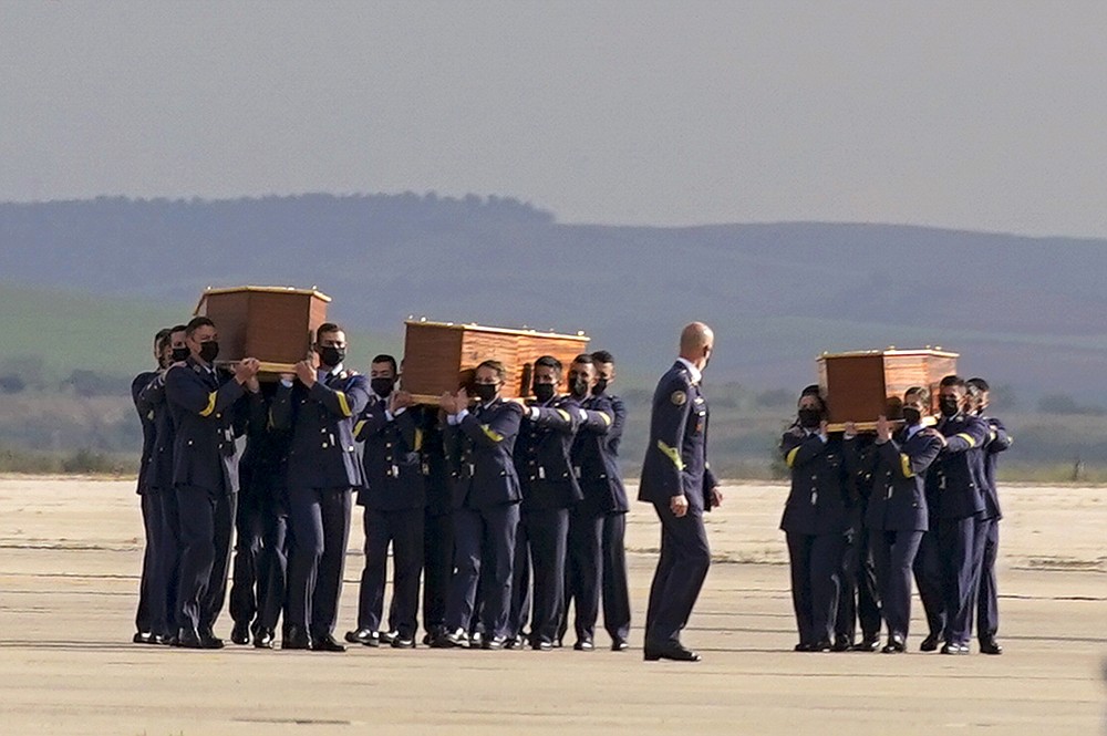 Coffins carrying the bodies of Spanish reporters David Beriain, Roberto Fraile and the director of the Chengeta Wildlife Foundation Rory Young, arrive from Burkina Faso at the Madrid military airport on Friday, April 30, 2021. Two Spanish journalists and the Irish director of a wildlife foundation were killed Monday in an ambush in eastern Burkina Faso. The two journalists were working with the wildlife campaigner on a documentary about poachers in a national park bordering Benin when they were attacked by gunmen. (AP Photo/Andrea Comas)