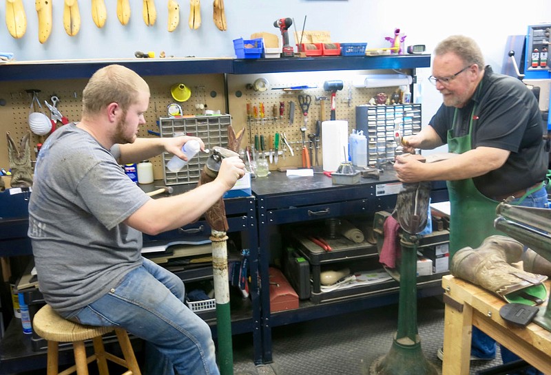 Westside Eagle Observer/SUSAN HOLLAND
Kaiser Falk and his father Danny Falk work side by side in their full service, boot, shoe and leather repair shop, Soles Saved and Heels Too. The Falks moved to Gravette in fall 2020 and spent a few months remodeling the location at 102B Main Streeet N.E. Entrance is off Highway 59. The Falks can be contacted at 479-802-0200 or on their Facebook page.