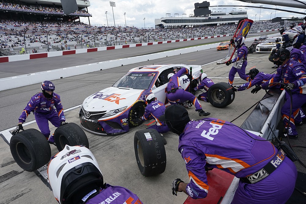 Denny Hamlin (11) gets service in the pits during the NASCAR Cup Series auto race at Richmond International Raceway in Richmond, Va., Sunday, April 18, 2021. (AP Photo/Steve Helber)